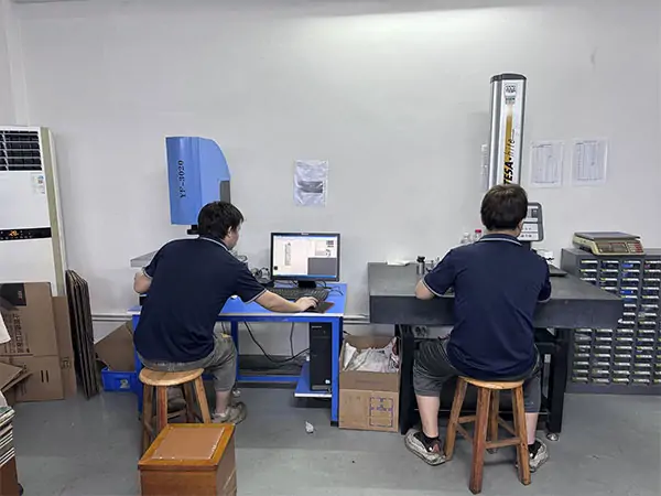 Operators performing CNC quality control using video measuring machine and TESA height gauge for precision inspection