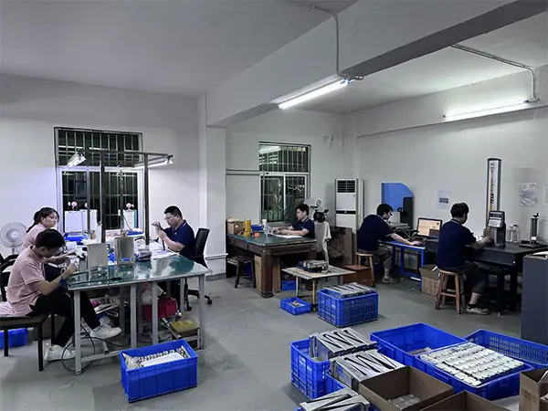 CNC quality inspection workshop with multiple operators performing precision testing and measurement
